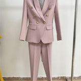 Pink suit with gold buttons on a hanger against a plain background