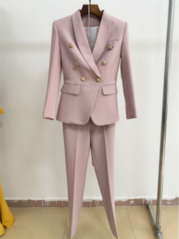 Pink suit with gold buttons on a hanger against a plain background
