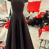 Dark gray dress on a mannequin against a blurred indoor background