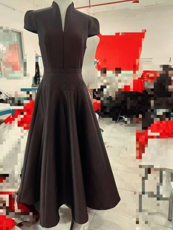 Dark gray dress on a mannequin against a blurred indoor background