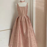 Pink dress on a mannequin against a neutral wall