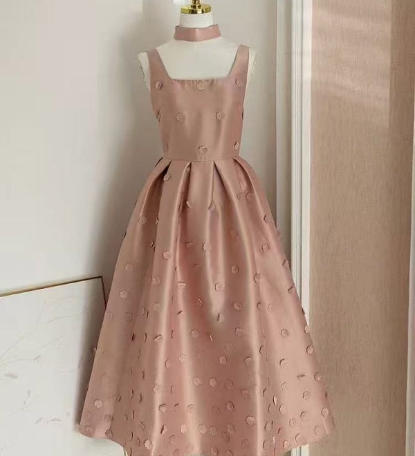 Pink dress on a mannequin against a neutral wall