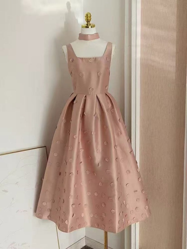 Pink dress on a mannequin against a neutral wall