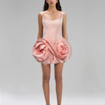 Pink dress with floral design worn by a model on a gray background