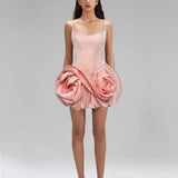 Pink dress with floral design worn by a model on a gray background