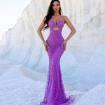Woman wearing a glamorous amethyst beaded mermaid gown with sweetheart neckline and intricate detailing, posing against a white rocky background