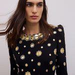 Model in black dress with gold embellishments