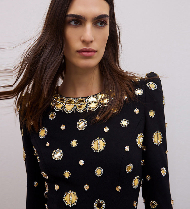 Model in black dress with gold embellishments