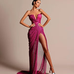 Elegant woman in fuchsia strapless evening gown with deep neckline and high slit, standing in studio setting