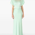 Woman in cape-sleeve gown with beaded neckline