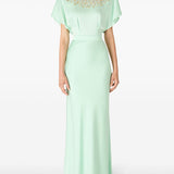 Woman in cape-sleeve gown with beaded neckline