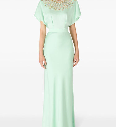 Woman in cape-sleeve gown with beaded neckline