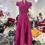 Magenta dress on a mannequin in a blurred indoor setting