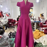 Magenta dress on a mannequin in a blurred indoor setting
