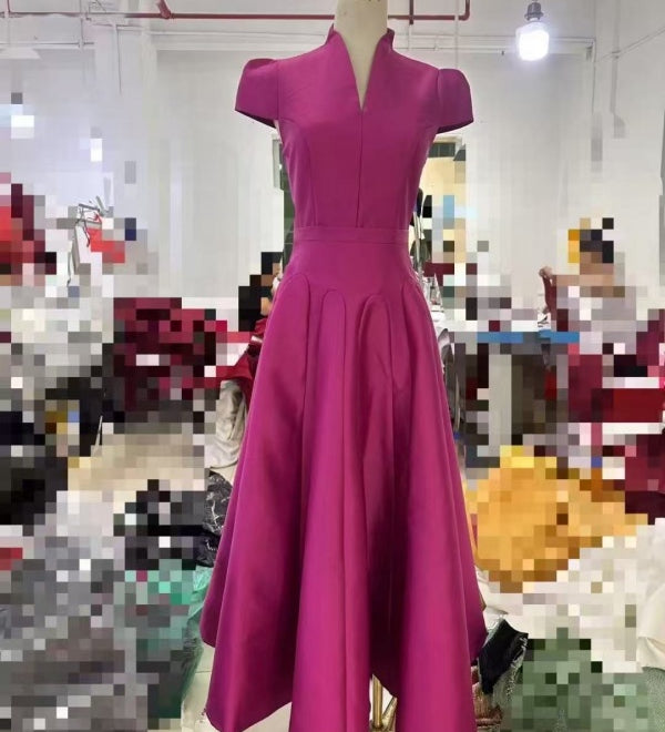 Magenta dress on a mannequin in a blurred indoor setting