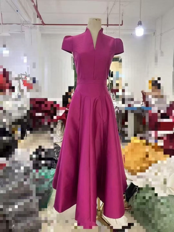 Magenta dress on a mannequin in a blurred indoor setting