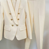 White suit jacket with gold buttons and matching pants on a hanger against a white background
