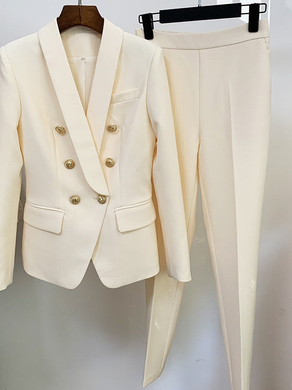 White suit jacket with gold buttons and matching pants on a hanger against a white background