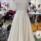 White dress on a mannequin against a blurred indoor background