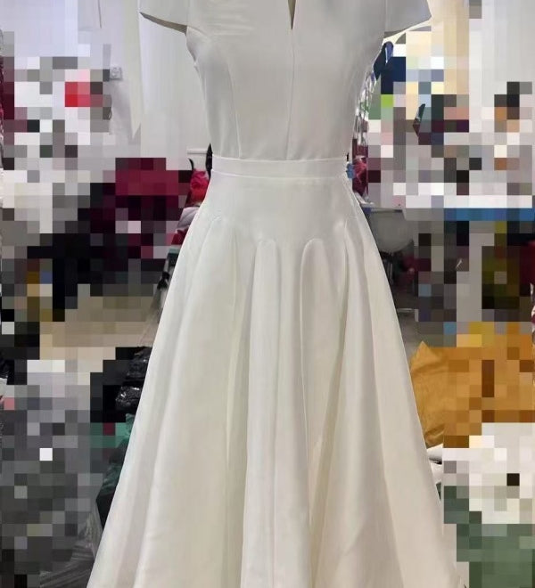 White dress on a mannequin against a blurred indoor background