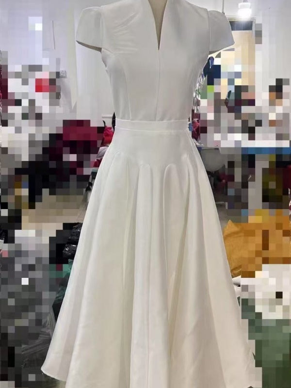 White dress on a mannequin against a blurred indoor background